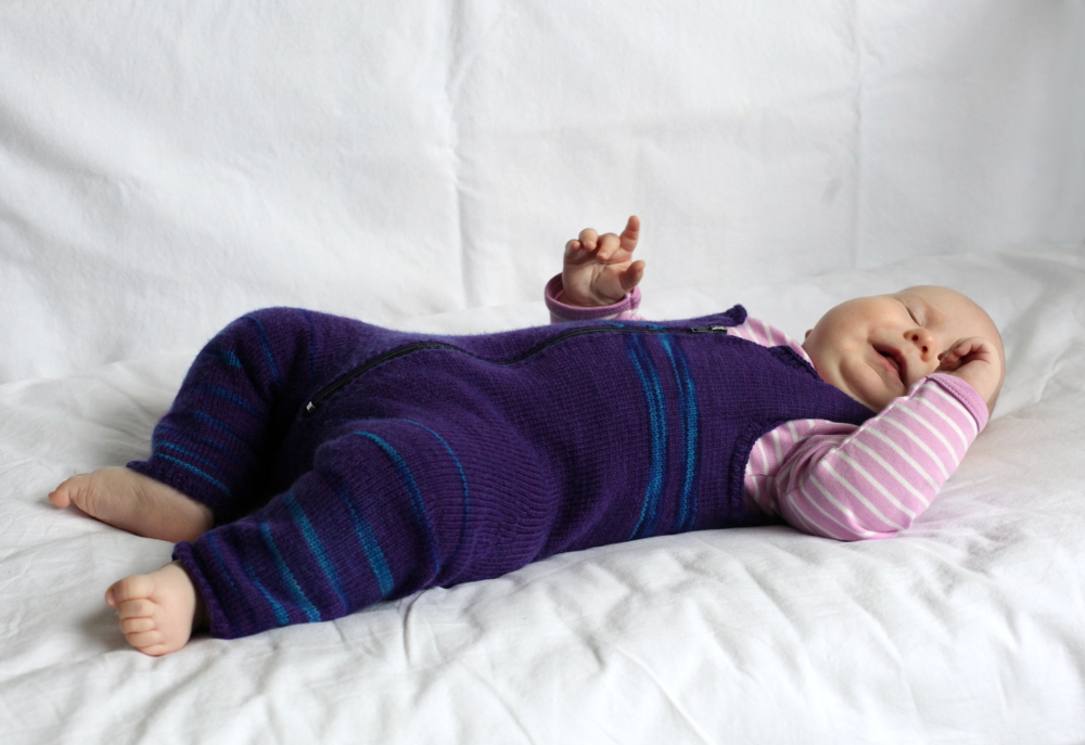 Baby wearing a purple. knitted overall